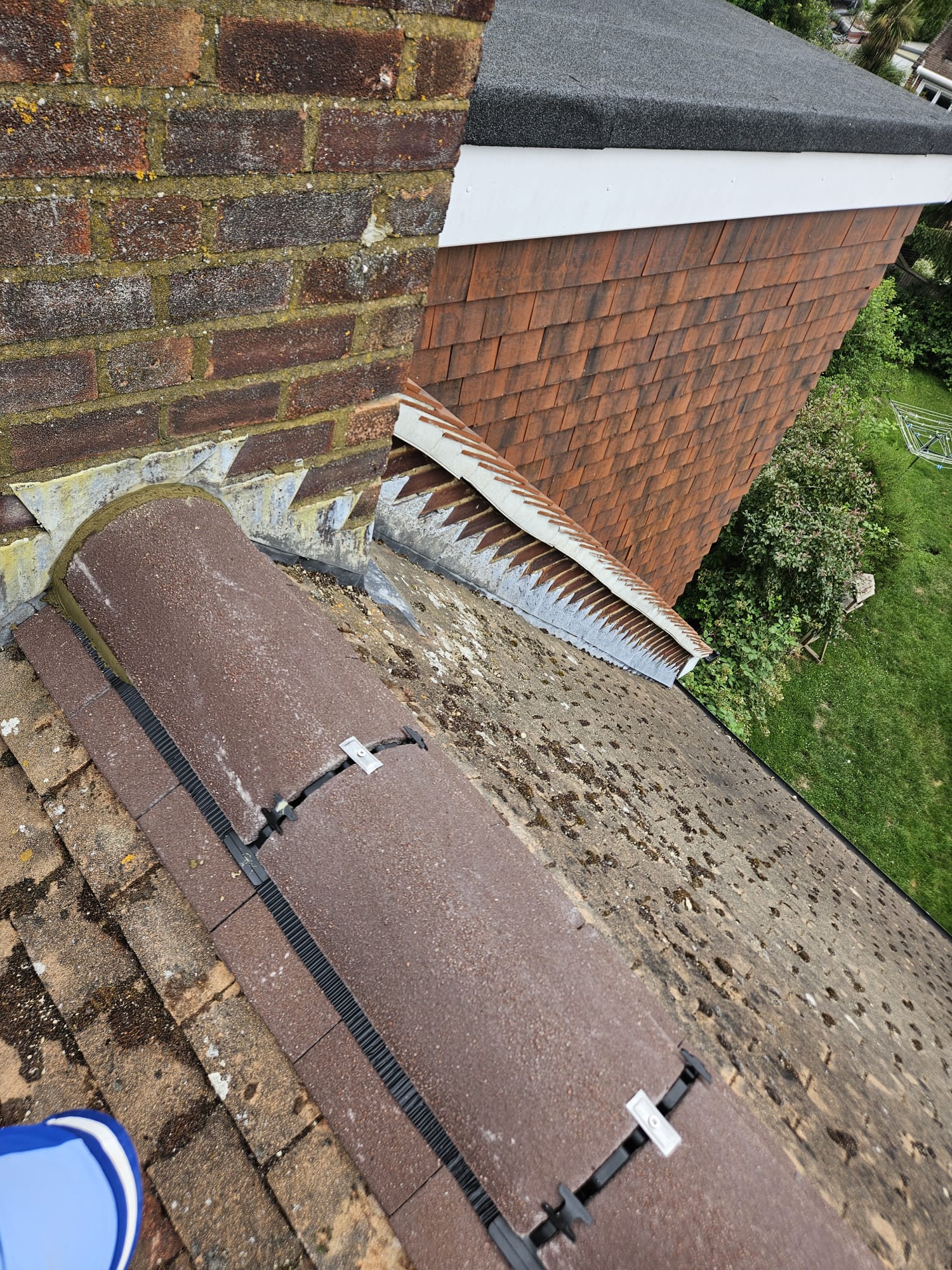 Lead flashing and soakers dressed into the chimney and verge abutment of a Surrey roof