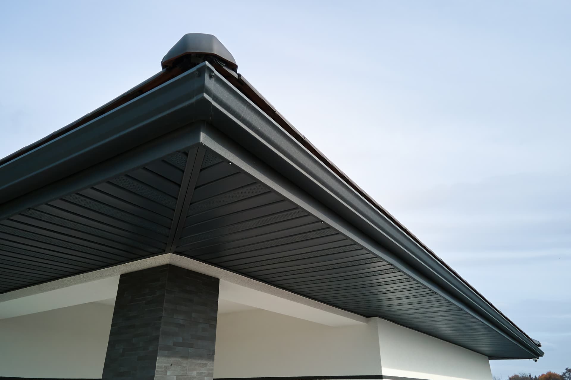 Close up of dark fascia boards and vented soffit boarding under a roof edge