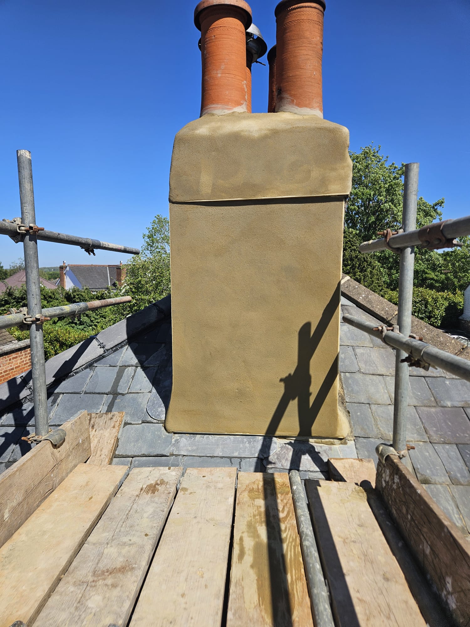 Chimney stack rebuilt and rendered with new flaunching above a Surrey slate roof