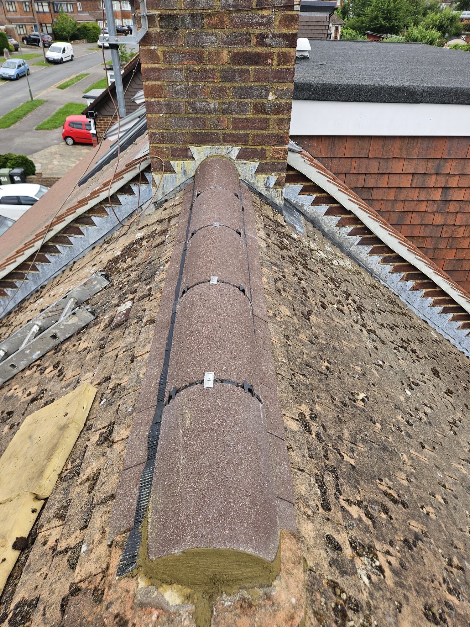 Dry fix ridge tiles being fitted along the ridge line of a Surrey roof