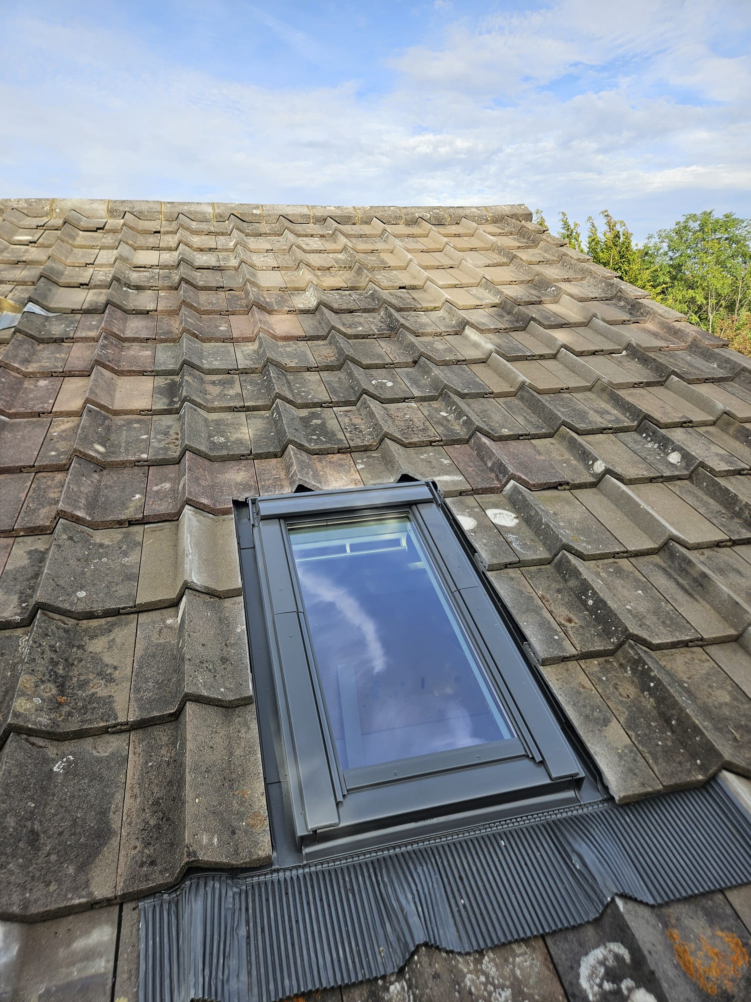 Velux roof window fitted with flashing kit into Surrey roof tiles
