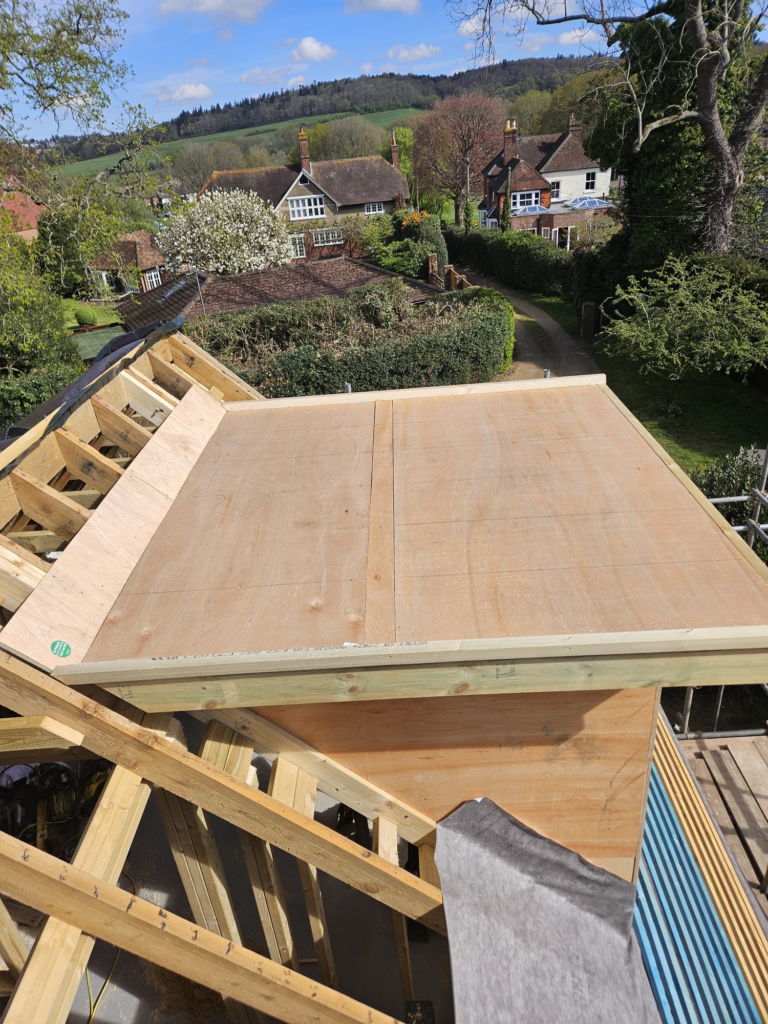 New flat roof section decked out in ply alongside new roof timbers in Surrey