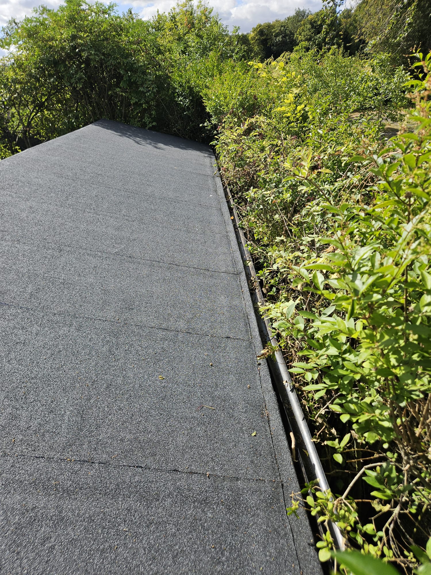 New black guttering and edge trim running along a roof line in Surrey