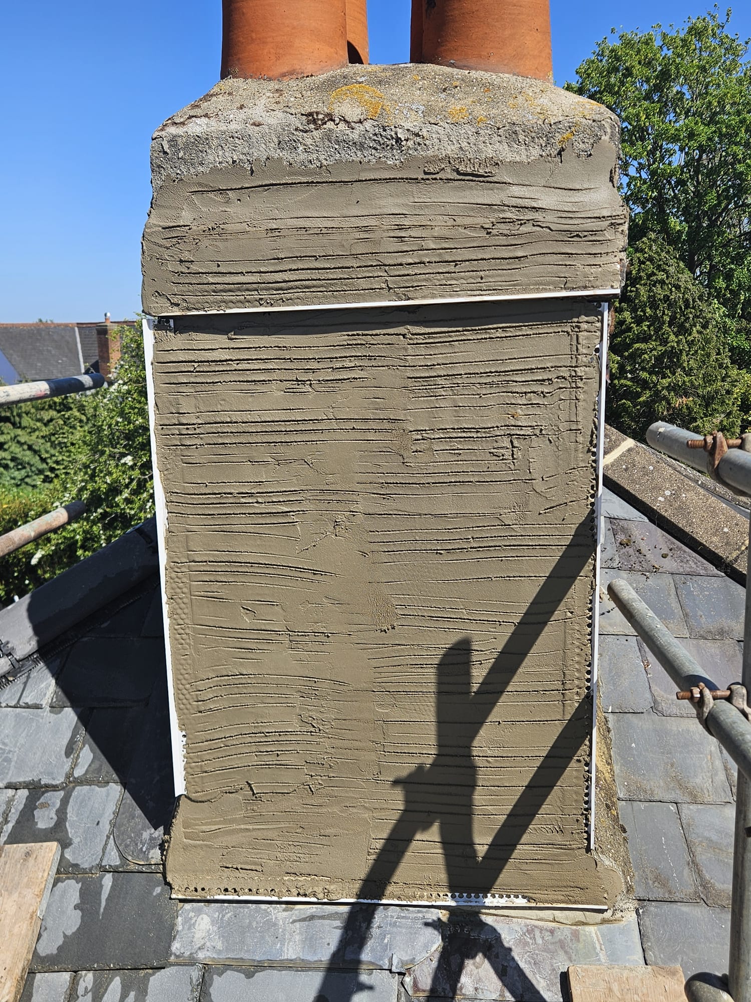 Chimney stack being rendered with new lead tray at the roof line in Surrey